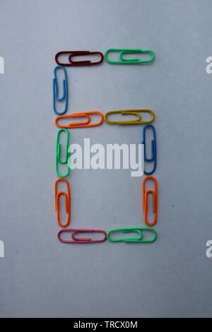 Number 6 made with colorful paper clips on white background Stock Photo