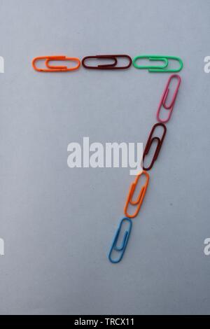 Number 7 made with colorful paper clips on white background Stock Photo