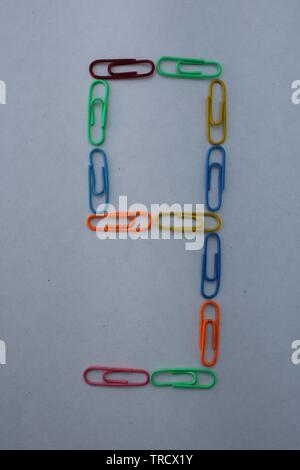 Number nine made with colorful paper clips on white background Stock Photo