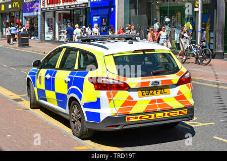 Shoppers in busy high street Essex police force patrol car high visibility markings in town centre shopping area in Southend on Sea  Essex England UK Stock Photo