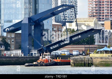 Entrance for tug boat to South Dock of West India Docks access to Canary Wharf estate via River Thames & raised modern road bridge London Docklands UK Stock Photo