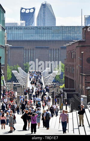 City of London street scene looking down from above crowd of people walking on millenium millennium bridge Tate Modern art gallery beyond England UK Stock Photo