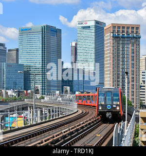 London Docklands financial banking district skyline at Canary Wharf with DLR passenger train railway tracks Barclays Bank & HSBC office HQ beyond UK Stock Photo