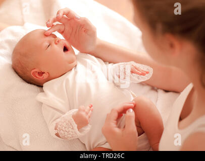 Small baby girl lying in mothers hands closeup. Woman holding infant girl. Motherhood. Stock Photo