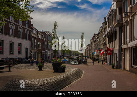 Gouda, Holland, Netherlands, April 23, 2019A little square in Gouda old town, bicycles parked near a bridge in a street of town. Flowers on the backgr Stock Photo