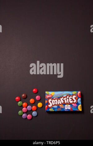 Halifax, Canada- May 31, 2019: Package of Smarties chocolate coated candy against a black background Stock Photo