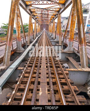 Vintage railroad tracks leading over the famous Long Bien Bridge, Hanoi, Vietnam. This is the railway line was built so long and still in operation to Stock Photo