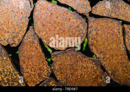 Abstract background of rusty brown metal parts with visible green elements through it Stock Photo