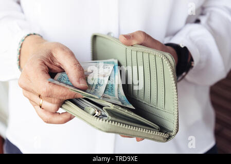 Close up of hand of woman taking out pounds from her purse Stock Photo