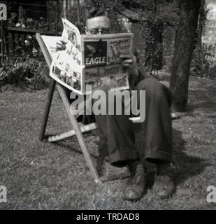 1950s, historical, man sitting in a deckchair outside in a garden reading the Eagle, a British comic, first published in England from 1950s to 1969, and then following a relaunch, from 1982 to 1994. Created by Marcus Morris and published by Hulton Press, it was enormously successful. Its most recognisable character was Dan Dare, Pilot of the Future, created by Frank Hampson. Stock Photo