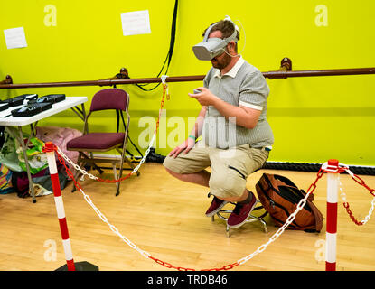 Great Yarmouth Comicon 2019 – Young man sitting on a chair immersed in a virtual reality computer game at the Comicon event in the seaside town of Gre Stock Photo