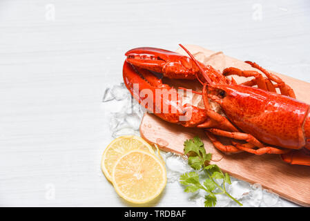 Lobster seafood with ice  on wooden cutting board and lemon coriander / Close up of steamed lobster food Stock Photo