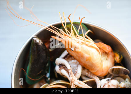Shellfish seafood plate with shrimps prawns mussel squid ocean gourmet dinner seafood cooked boiled in hot pot with herbs and spices on table backgrou Stock Photo