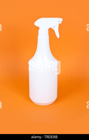 white plastic spray on orange background Stock Photo
