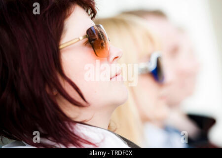 Group portrait/close up of 4 young persons wearing sunglasses sitting Stock Photo