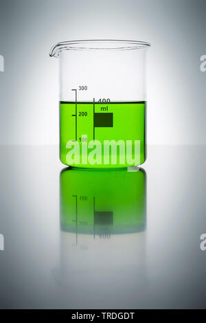 Beaker glass filled with green liquid against grey background Stock Photo