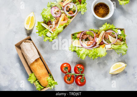 Chicken Kiev cutlets and Salad with smoked salmon in takeaway Box. Ukrainian tradition food. Top view Stock Photo