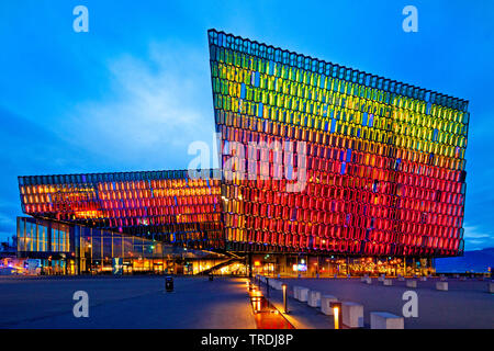 illuminated Harpa concert hall with distinctive colored glass facace in the evening, Iceland, Reykjavik Stock Photo