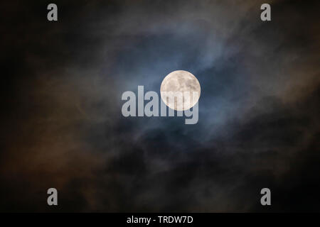 full moon with halo shining through the clouds, Germany, Bavaria Stock Photo