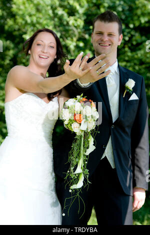 Bridal couple showing off their wedding rings after the ceremony Stock Photo