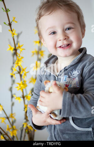 Portrait of a young boy holding a stuffed animal smiling into the camera Stock Photo