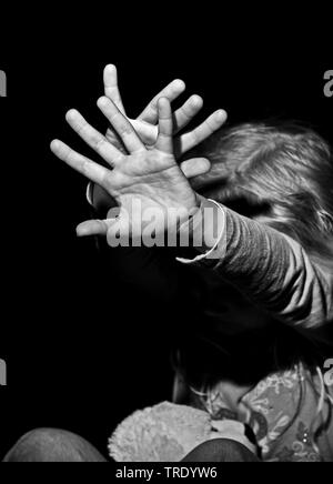 Portrait of a young girl outstreching her arms for protection - child abuse (black-and-white photo) Stock Photo