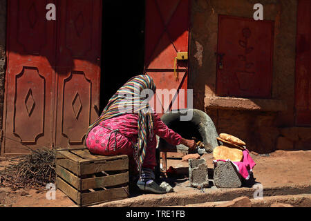 woman baking bread at the roadside, Morocco, Hoher Atlas, Oukaimeden Stock Photo