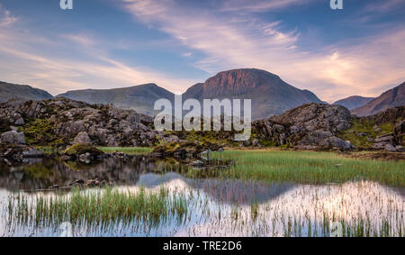 The warm morning light on the lakeland mountain of Great Gable reflecting in Innominate Tarn Stock Photo