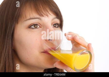 Face of a young woman drinking a glass of orange juice Stock Photo