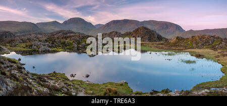 The warm morning light on the lakeland mountain of Great Gable reflecting in Innominate Tarn Stock Photo