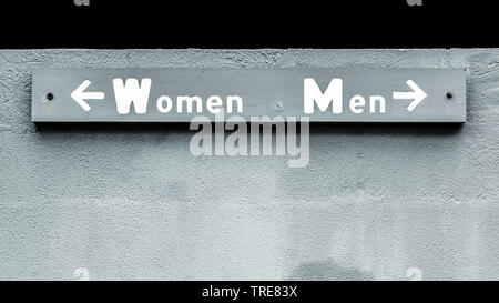 sign with the words for women and man, arrows pointing in opposite directions Stock Photo