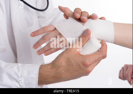 Close up of a doctor putting a bandage on a female wrist Stock Photo