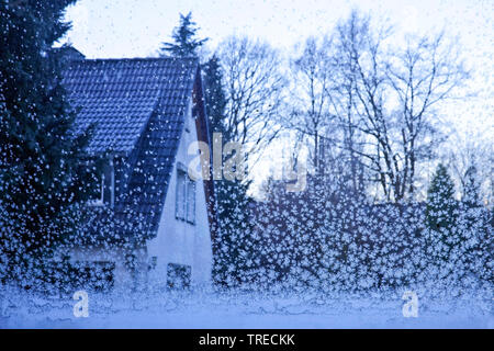 view through a window pane with ice crystals to a residential house, Germany, North Rhine-Westphalia, Ruhr Area, Witten Stock Photo