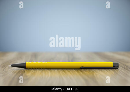 3D computer graphic, yellow pen on top of a wooden surface Stock Photo