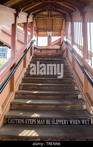 Close-up rising wooden gantry stairway, staircase, steps at vintage UK railway station, SVR heritage line. Caution: slippery when wet. Stock Photo