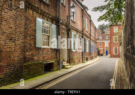 Old traditional British terraced houses along a narrow street Stock Photo