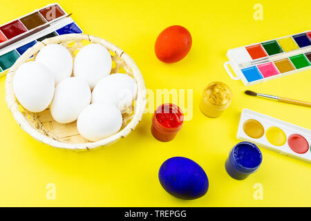 A woman with a tassel paints Easter eggs. Preparing decorations for ...