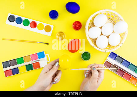 A woman with a tassel paints Easter eggs. Preparing decorations for ...