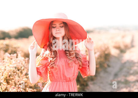 Beautiful teenage girl 14-16 year old wearing stylish pink dress and hat  outdoors. Posing in meadow. Childhood Stock Photo - Alamy