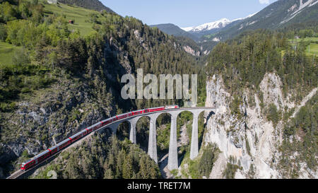 Viaduct of Landwasser and red train of Bernina. Bernina Glaciers on railway. Filisur, Albula. Stock Photo