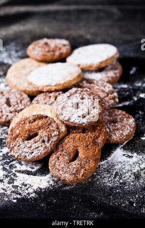 Chocolate chip and oat fresh cookies with sugar powder heap on black background. Stock Photo