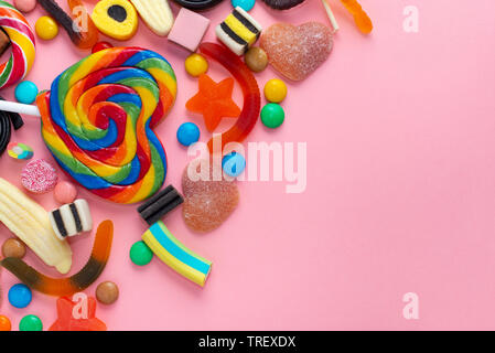 mixed colorful sweets lollipops and candies over pink like festive background with copy space Stock Photo