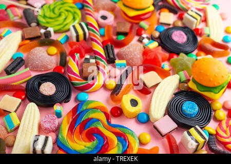 mixed colorful sweet candies with jelly over pink festive background Stock Photo