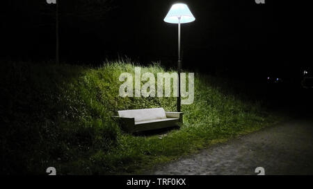 A bench that looks like a sofa under a street lamp that looks like a house lamp in the park in Bain-de-Bretagne Stock Photo