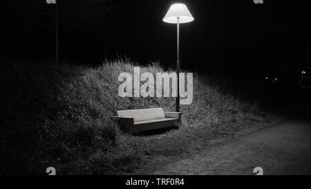 A bench that looks like a sofa under a street lamp that looks like a house lamp in the park in Bain-de-Bretagne Stock Photo