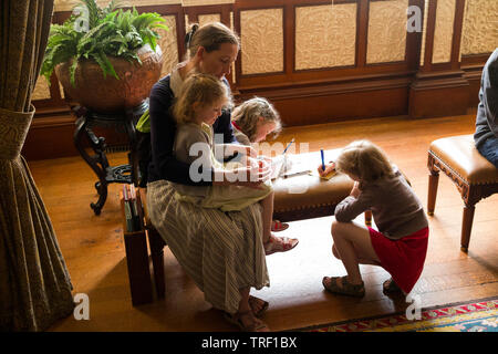 Mother / mum and three children complete mystery trail questionnaire challenge activity in a stately home / house on the Isle of Wight. UK. (99) Stock Photo