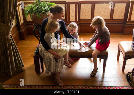 Mother / mum and three children complete mystery trail questionnaire challenge activity in a stately home / house on the Isle of Wight. UK. (99) Stock Photo