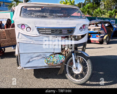 Puerto Princesa City, Palawan, Philippines: White cabin tricycle with driver looking for passengers in the city streets Stock Photo