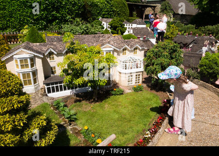 Girl / girls / child / children / kid / kids explore the Model Village at Godshill on the Isle of Wight, on a sunny day with blue sky / skies. (99) Stock Photo