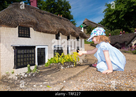 Girl / girls / child / children / kid / kids explore the Model Village at Godshill on the Isle of Wight, on a sunny day with blue sky / skies. (99) Stock Photo